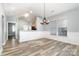 Bright dining area showcasing wood-look floors, modern chandelier, and wainscoting, adjacent to kitchen at 9644 Marquette Nw St, Concord, NC 28027