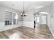 Bright dining area showcasing wood-look floors, modern chandelier, and wainscoting, adjacent to living spaces at 9644 Marquette Nw St, Concord, NC 28027