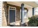 Stone-accented entryway with a dark front door, window, and stately columns create inviting curb appeal at 9644 Marquette Nw St, Concord, NC 28027