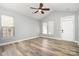Bright, open living room featuring vaulted ceiling, ceiling fan, wood-look floors, and ample natural light at 9644 Marquette Nw St, Concord, NC 28027