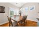 Bright dining area with hardwood floors, a rustic wooden table, and a sliding glass door to the backyard at 1108 Mayapple Way, Belmont, NC 28012