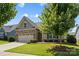Charming home with a stone and shingle facade, well-manicured lawn, and an attached two-car garage at 1108 Mayapple Way, Belmont, NC 28012