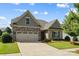 Charming home with a stone and shingle facade, well-manicured lawn, and an attached two-car garage at 1108 Mayapple Way, Belmont, NC 28012