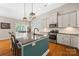 An open-concept kitchen and dining area features an island with seating, granite counters, and stainless appliances at 1108 Mayapple Way, Belmont, NC 28012