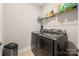Laundry room boasting modern, front-loading washer and dryer with storage shelf at 1108 Mayapple Way, Belmont, NC 28012