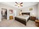 A comfortable main bedroom boasts a tray ceiling, a ceiling fan, carpet, and access to the bathroom and closet at 1108 Mayapple Way, Belmont, NC 28012