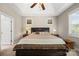 A spacious main bedroom features a tray ceiling, ceiling fan, carpet, and windows with blinds at 1108 Mayapple Way, Belmont, NC 28012