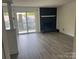Sunlit living room featuring a fireplace, modern flooring, and access to a deck at 11123 Harrowfield Rd, Charlotte, NC 28226