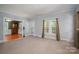 Spacious living room featuring neutral carpet, an open doorway, and ample natural light at 1173 Cat Square Rd, Vale, NC 28168