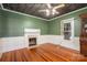 Room with vintage desk, wood floors, green walls, and white trim around the fireplace at 1173 Cat Square Rd, Vale, NC 28168