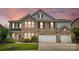 Beautiful two-story brick home featuring a two-car garage and manicured lawn with an inviting sunset in the background at 1281 Arges River Dr, Fort Mill, SC 29715