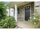 Inviting entryway featuring a black front door, brick facade, and lush landscaping with colorful flowering plants at 1281 Arges River Dr, Fort Mill, SC 29715
