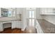 Long kitchen with built in desk area, granite countertops and hardwood flooring at 1281 Arges River Dr, Fort Mill, SC 29715