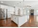 Open concept kitchen features stainless steel appliances, white cabinets, large island, and hardwood floors at 1281 Arges River Dr, Fort Mill, SC 29715
