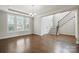 Bright living room with hardwood floors, large windows and staircase access to the upper level at 1281 Arges River Dr, Fort Mill, SC 29715