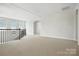Upstairs loft area with neutral walls, carpeted floors, a staircase, and natural light from multiple windows at 1281 Arges River Dr, Fort Mill, SC 29715