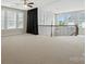 Upstairs loft with neutral walls, carpeted floors, staircase, and natural light from multiple windows at 1281 Arges River Dr, Fort Mill, SC 29715