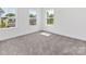 Spacious bedroom featuring plush carpeting and three bright windows offering outdoor views at 1516 Respect Nw St, Concord, NC 28027