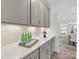 Butler's pantry features gray cabinets, quartz countertops, and open access to the dining area at 1516 Respect Nw St, Concord, NC 28027