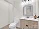 Bathroom with a single sink vanity, white toilet, and modern light fixture at 172 Wildwood Loop, Statesville, NC 28625