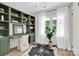 Home office with built-in green shelving, a desk, a large window, and decorative plants at 172 Wildwood Loop, Statesville, NC 28625