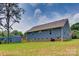 Spacious backyard showing the home's exterior with siding and a storage shed in a grassy yard at 1916 Bess Town Rd, Bessemer City, NC 28016