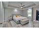 Bright bedroom with tray ceiling, ceiling fan, decorative rug, and upholstered bench at the foot of the bed at 1916 Bess Town Rd, Bessemer City, NC 28016
