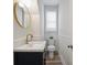 Stylish powder room with modern fixtures, vanity and a round mirror at 20444 Greenway Heights Dr, Cornelius, NC 28031