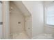 A compact laundry room with white tile flooring, shelving, and a utility sink, maximizing space efficiency at 20444 Greenway Heights Dr, Cornelius, NC 28031