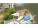 Stunning aerial view of lakefront home with pool, fire pit area, and meticulous landscaping at 216 Grand View Dr, New London, NC 28127
