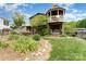 Backyard view of the house with an upper deck, lower patio, lush landscaping, and hot tub at 216 Grand View Dr, New London, NC 28127