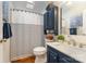 Charming bathroom features a single sink, wood floors, and a shower-tub with a stylish striped curtain at 216 Grand View Dr, New London, NC 28127