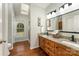Bright bathroom with double sink vanity, granite counters, wood floors, and natural lighting at 216 Grand View Dr, New London, NC 28127