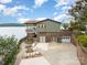Charming lakefront home with a brick base, upper balcony, patio, and fire pit area at 216 Grand View Dr, New London, NC 28127