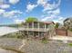 Elevated view of a multi-level home with lake access, featuring decks and patios at 216 Grand View Dr, New London, NC 28127