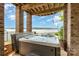 Relaxing hot tub with a scenic lake view, set beneath a covered patio with exposed wood beams at 216 Grand View Dr, New London, NC 28127