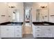 Dual sink bathroom vanity with black countertops, white cabinetry, and modern lighting fixtures at 307 Stoneyard Rd, Richfield, NC 28137