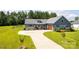 A stunning one-story home with gray siding, stone accents, a manicured lawn, and a long driveway at 307 Stoneyard Rd, Richfield, NC 28137