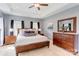 Large main bedroom with wood furniture, tray ceiling, and two windows dressed with dark colored curtains at 307 Stoneyard Rd, Richfield, NC 28137