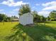 Backyard shed featuring wood door surrounded by vibrant greenery at 3206 Basilwood Cir, Monroe, NC 28110