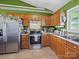 Well-lit kitchen featuring stainless steel appliances, tiled floor, and wooden cabinetry at 3206 Basilwood Cir, Monroe, NC 28110