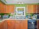 Efficient kitchen with wooden cabinets, modern appliances, and double sink under a bright window at 3206 Basilwood Cir, Monroe, NC 28110
