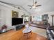 Spacious living room with hardwood floors, comfortable seating, and a large TV at 3206 Basilwood Cir, Monroe, NC 28110