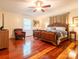 Spacious bedroom with ceiling fan, wood floors, and a luxurious king size bed at 3711 Davis Dr, Charlotte, NC 28270