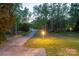 Long driveway leading to a charming home surrounded by mature trees and lush landscaping at 3711 Davis Dr, Charlotte, NC 28270