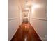 Inviting hallway with paneled walls, hardwood floors, and decorative lighting leading to rooms at 3711 Davis Dr, Charlotte, NC 28270