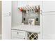 Kitchen area with wine rack, wine glass holder, white cabinets and metallic backsplash at 3711 Davis Dr, Charlotte, NC 28270