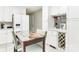 Bright eat-in kitchen featuring white cabinets, stainless steel appliances, wine rack and marble top table at 3711 Davis Dr, Charlotte, NC 28270