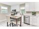 Bright kitchen featuring white cabinets, stainless steel appliances, and a marble top dining table at 3711 Davis Dr, Charlotte, NC 28270