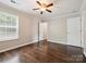 Spacious bedroom with hardwood floors, a ceiling fan, and a large window for natural light at 3830 Brookchase Ln, Charlotte, NC 28205